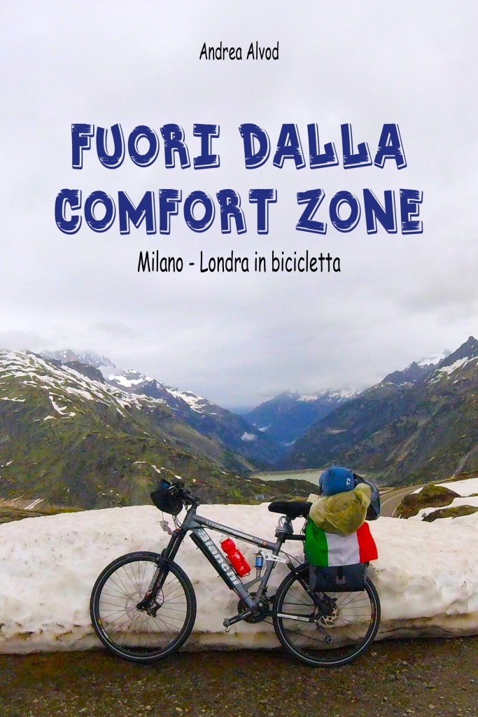 Copertina del libro 'Fuori dalla comfort zone' di Andrea Alvod, con una bicicletta parcheggiata su un paesaggio montano, mentre un bambino con un cappello blu e una giacca gialla osserva il panorama. La bicicletta ha una bandiera italiana attaccata al sedile.