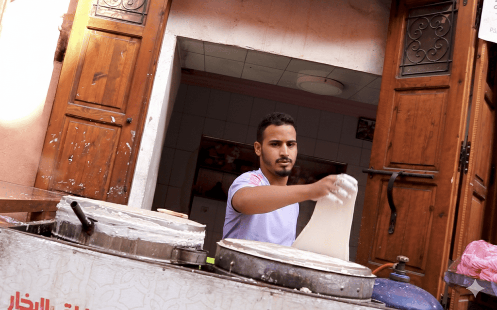 Foto in Marocco di un uomo che impasta a mani nude una tipica focaccia marocchina.