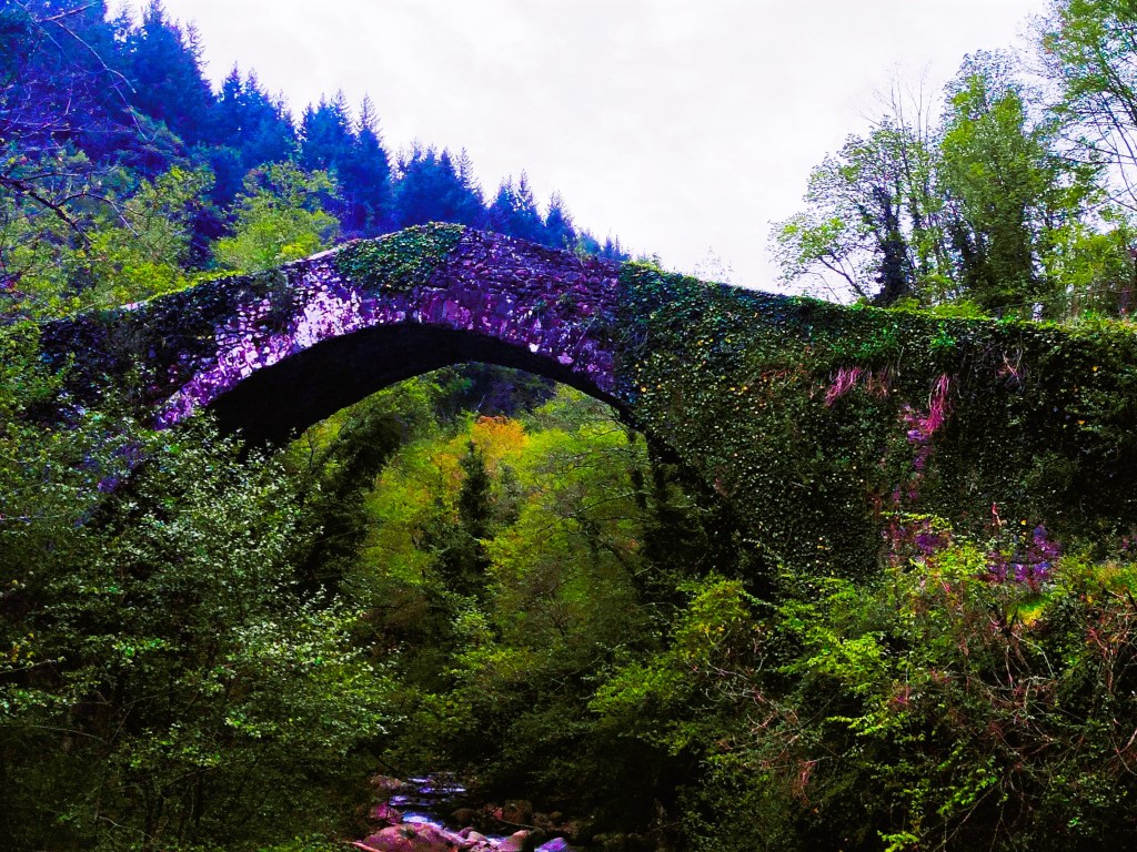 An ancient stone bridge covered in greenery, arching over a lush forested area with trees and shrubs.