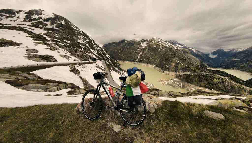 La Bianchi di Andrea carica di borse e con la bandiera italiana sul Passo della Novena, in discesa sul versante svizzero, durante il viaggio in bici dall’Italia a Londra (2016)