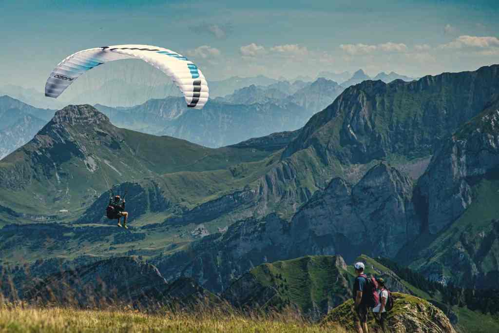 Parapendio in volo sopra una valle di montagna