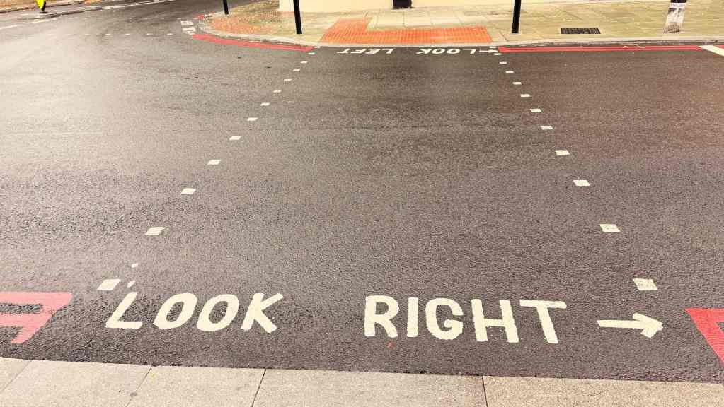 Scritte LOOK RIGHT e LOOK LEFT dipinte sull’asfalto di un attraversamento pedonale a Londra