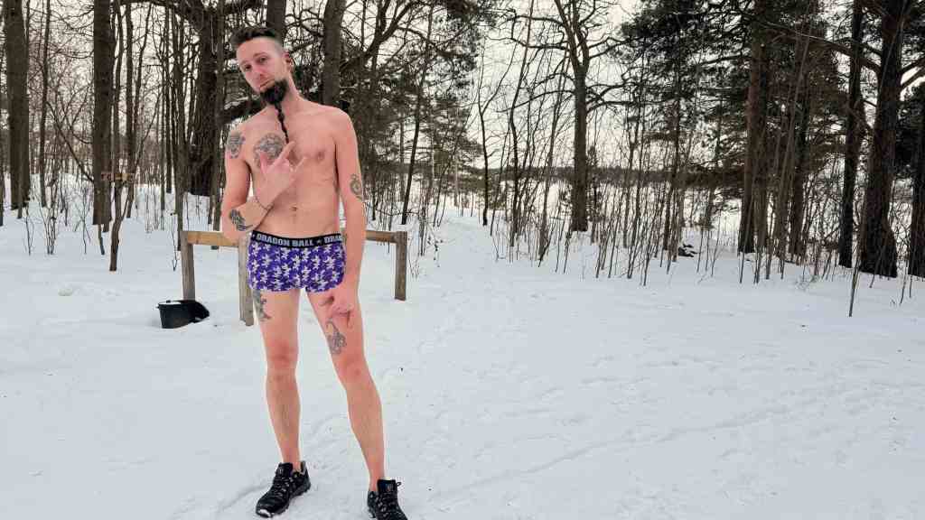 Andrea in boxer nella neve davanti agli appendiabiti della Sompasauna, a meno dieci gradi.